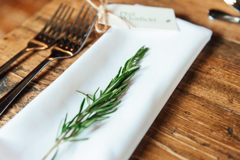Rustic wedding details with sprigs of rosemary as decoration 
