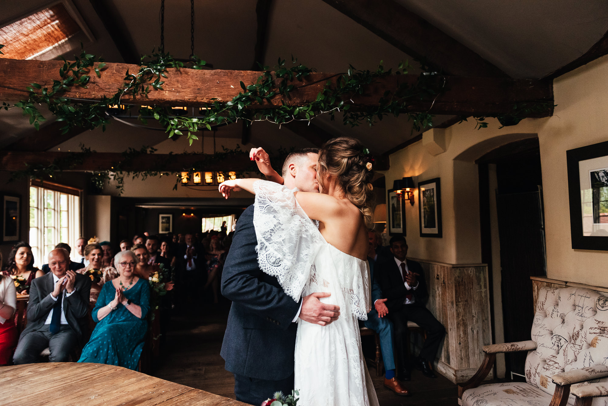 Bride and groom share a passionate first kiss at their The Mill at Elstead Wedding