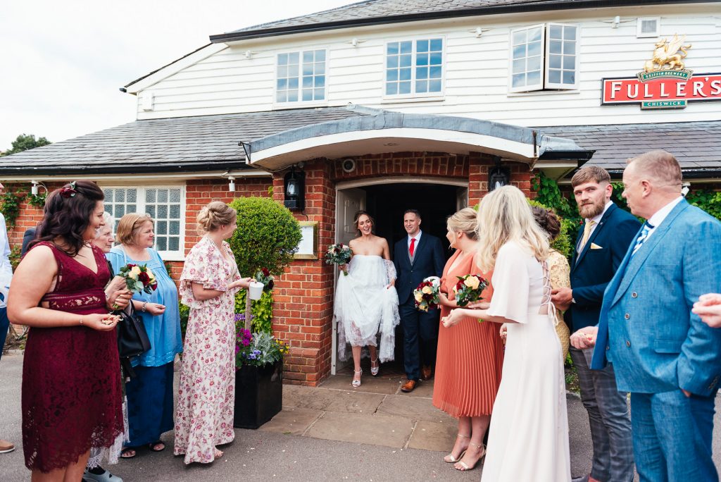 Couple enter the confetti line outside The Elstead Mill