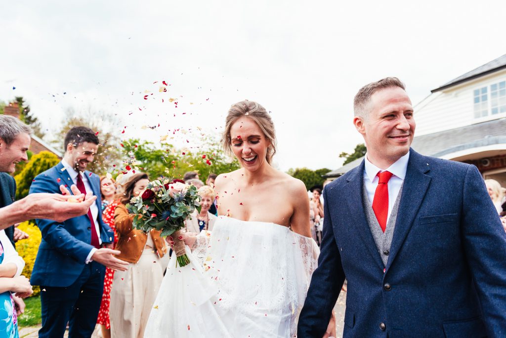Couple enter the confetti line outside The Elstead Mill