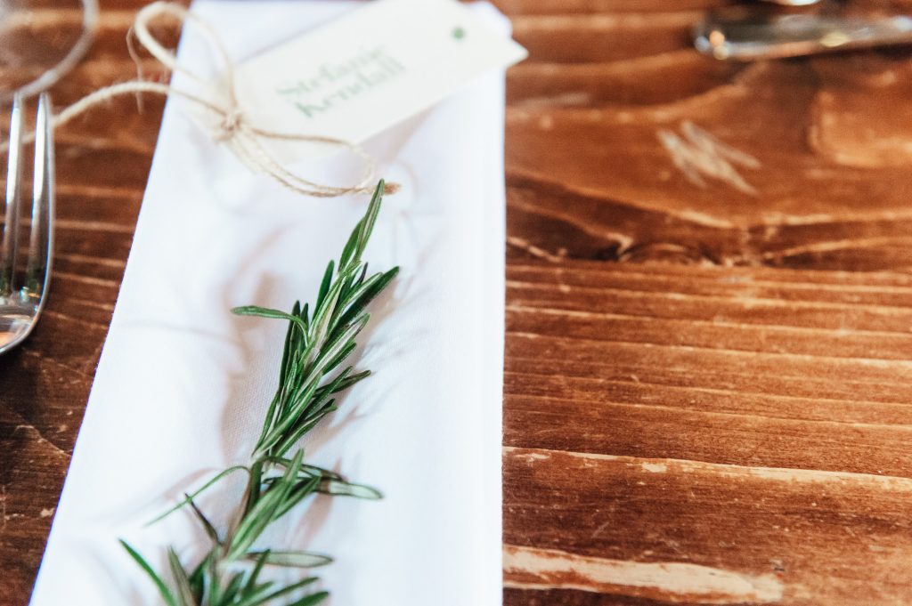 Rustic wedding details with sprigs of rosemary as decoration 