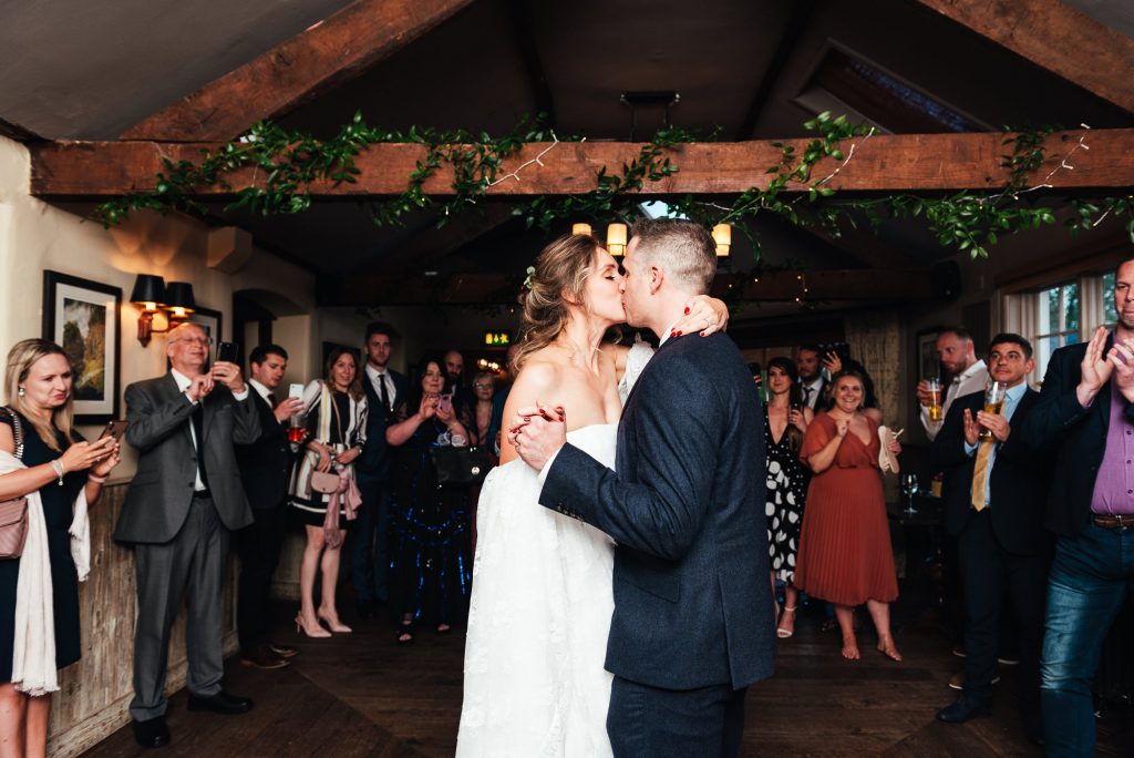 Couple share their first dance, the bride and groom kiss on the dancefloor