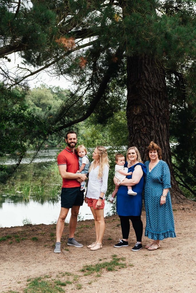 Family stand together in front of Virginia Water Lake