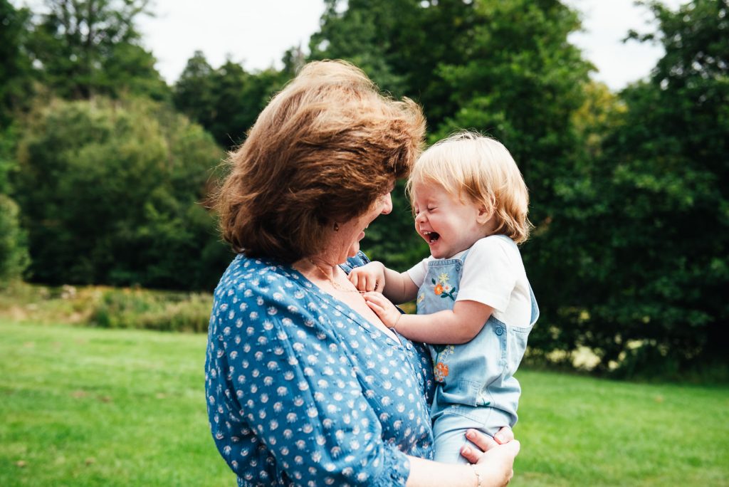 Virginia Water Family Photography, Grandmother and grandchild laugh towards the camera