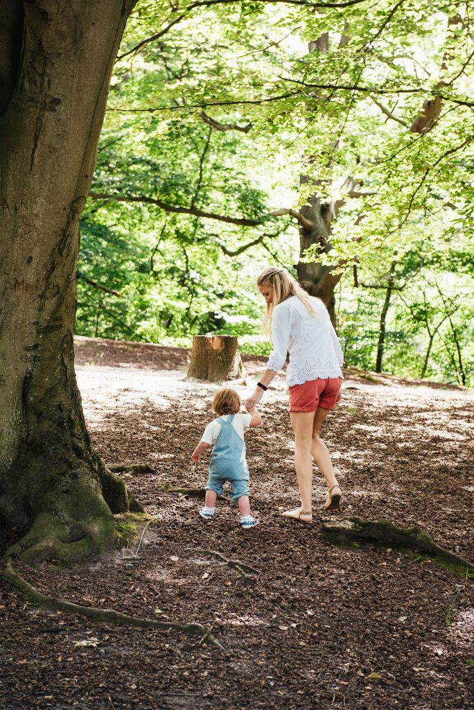 Candid mother and daughter moment walking together in the woods