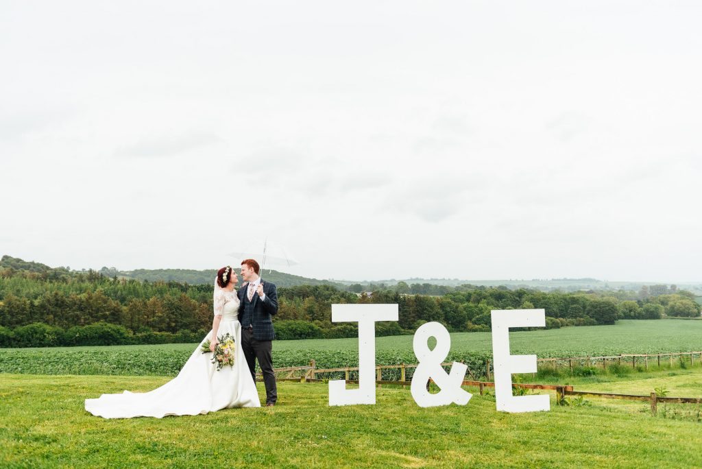 Creative couples portrait with home made initial signs