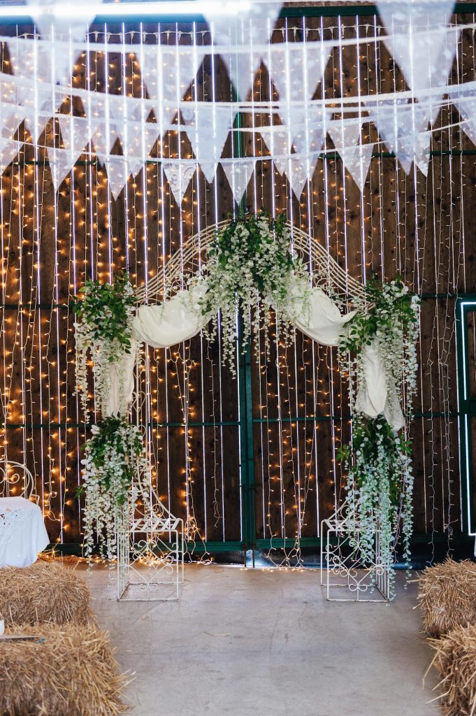 Fairy light backdrop with foliage flower arch