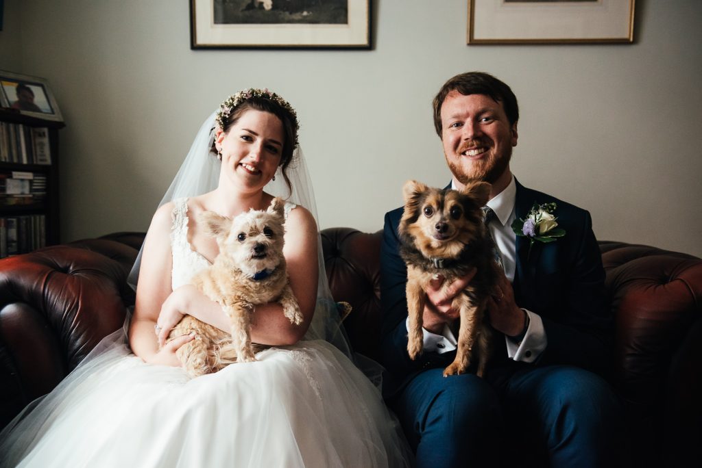 Bride and groom spend a moment with their dogs on their wedding day