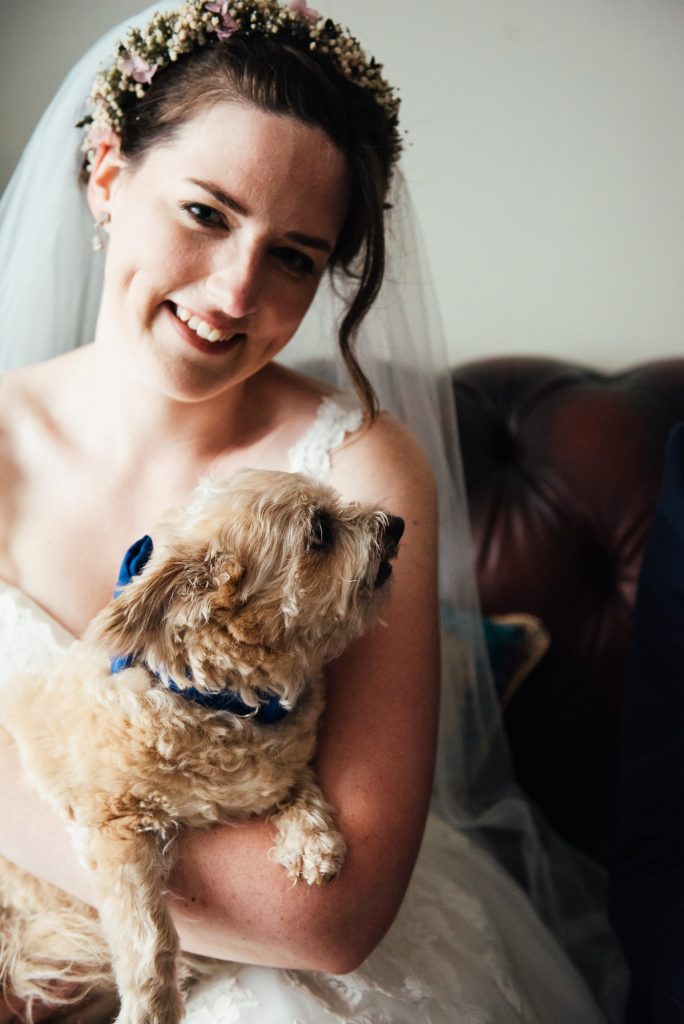 Bride and groom spend a moment with their dogs on their wedding day