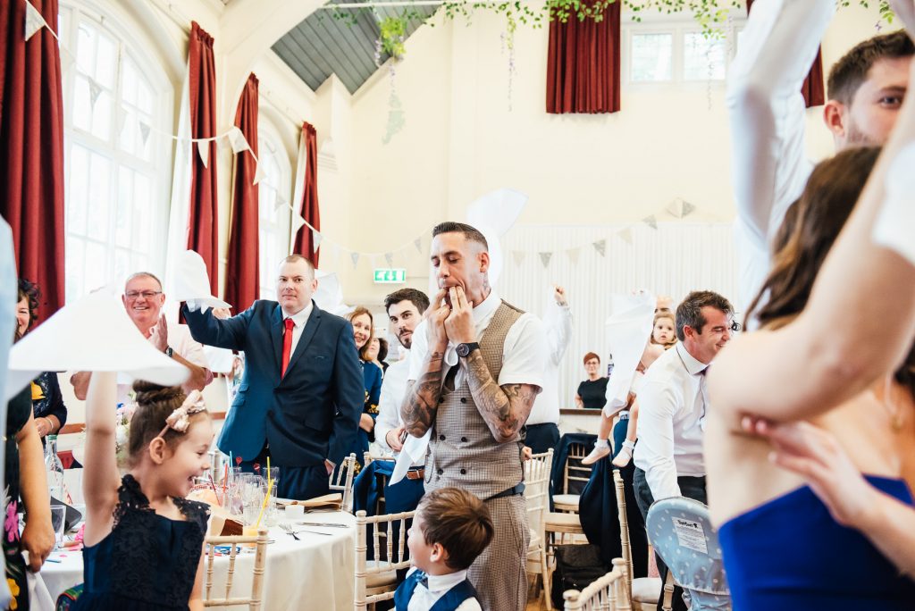 Guests cheer and welcome the bride and groom for DIY village hall wedding