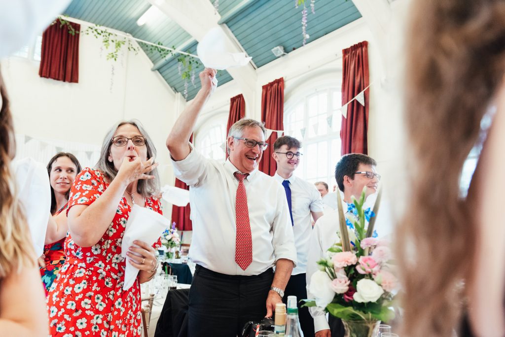 Guests cheer and welcome the bride and groom for DIY village hall wedding