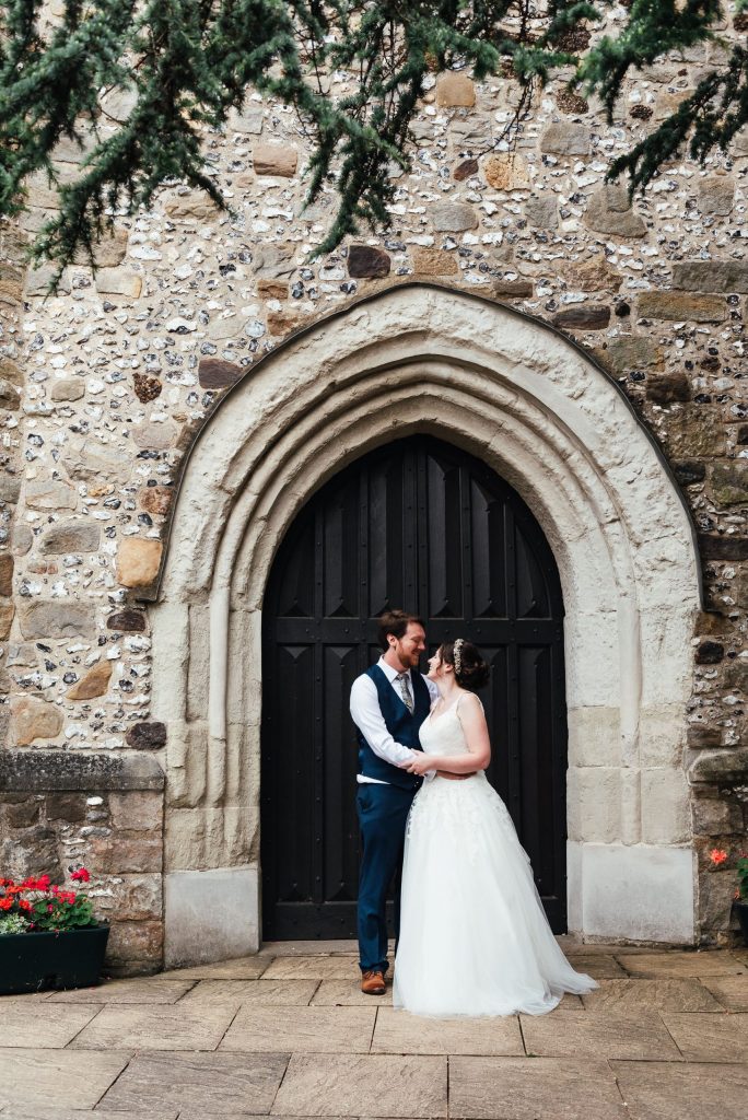 Bride and groom couples portrait with beautiful church door