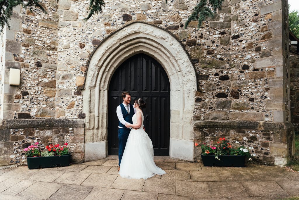 Bride and groom couples portrait with beautiful church door