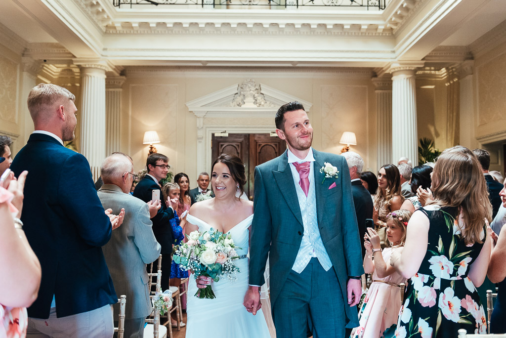 Bride and groom walk down the aisle for the first time as husband and wife