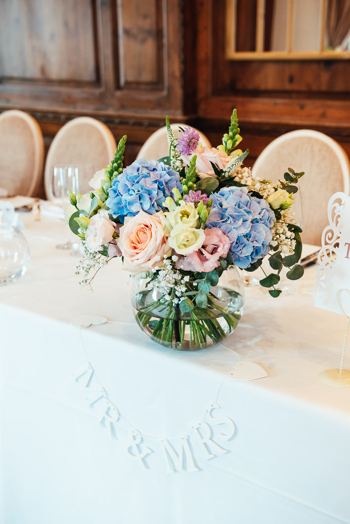 Beautiful table setting flower bouquets with blue hydrangea and pink roses 
