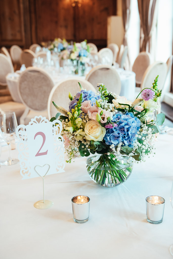 Beautiful table setting flower bouquets with blue hydrangea and pink roses 