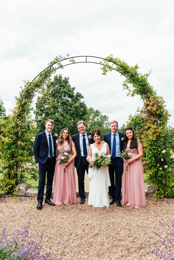 Family stand in front of flower arch at Oatland Park Hotel