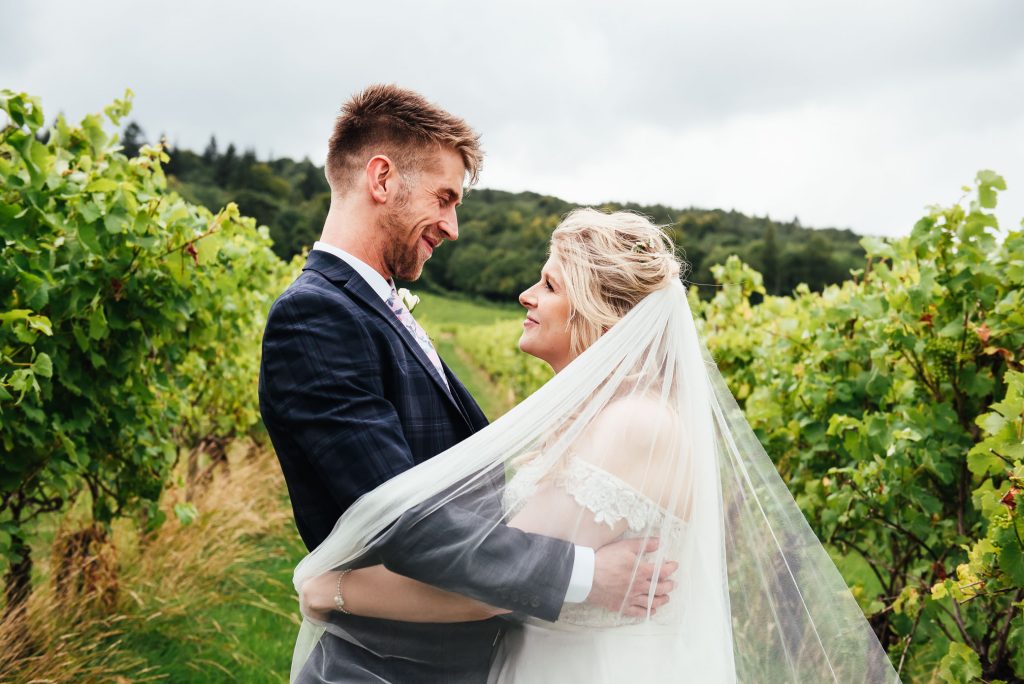 Couple embrace in the middle of Surrey vineyard