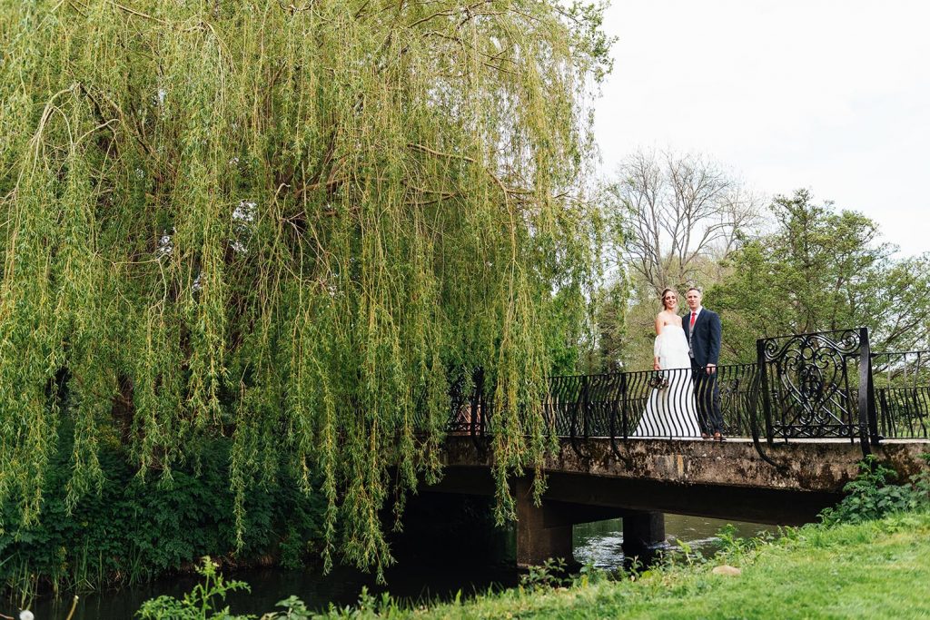 Surrey wedding venues, couple stand on the bridge at Elstead Mill