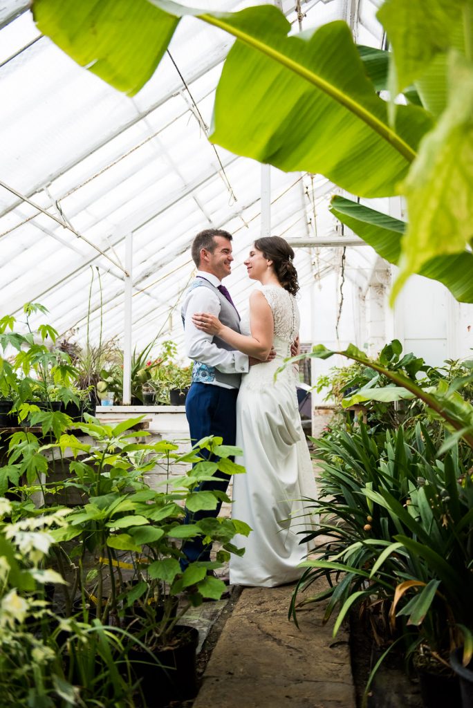 Couple embrace in the green house at Barnett Hill Hotel, Surrey Wedding Venues
