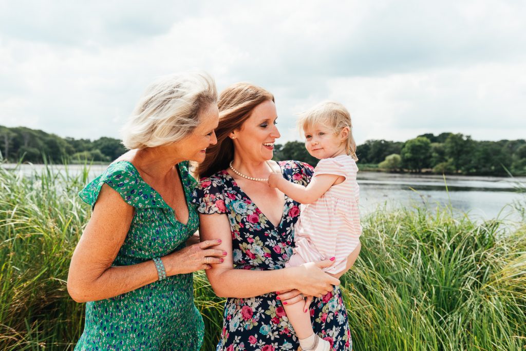 Family smile and coo over little girl at Richmond Park family shoot