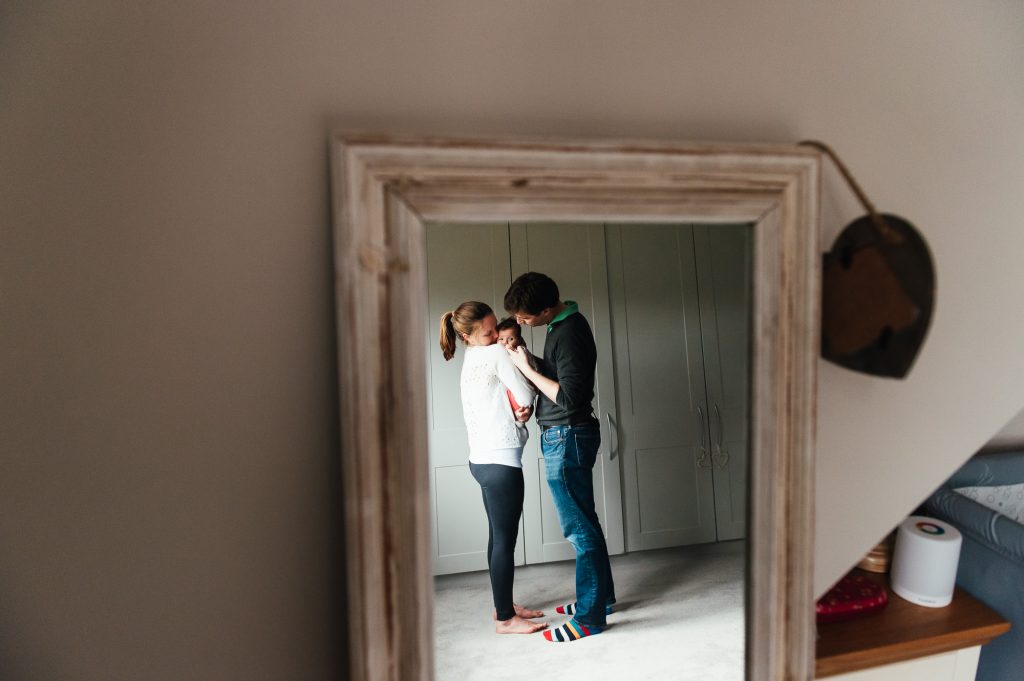 Family share a cuddle in mirror reflection, creative family photography