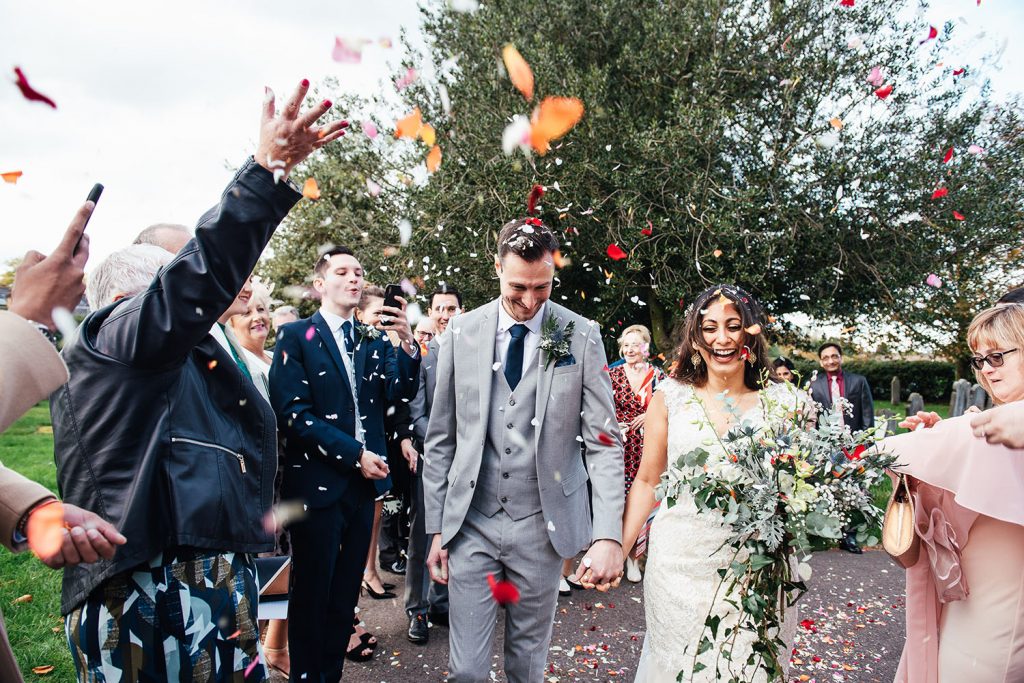 Couple walk through colourful confetti for a North London wedding