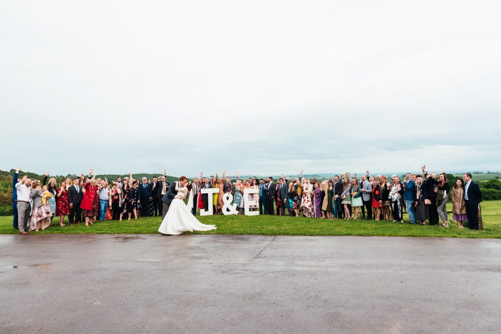 Fun outdoor wedding photography group portrait with home made wedding letter signs