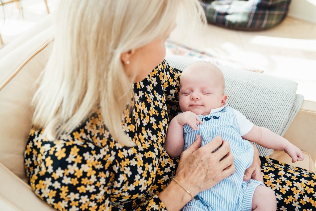 Grandmother holds her grandson in gorgeous airy and bright conservatory