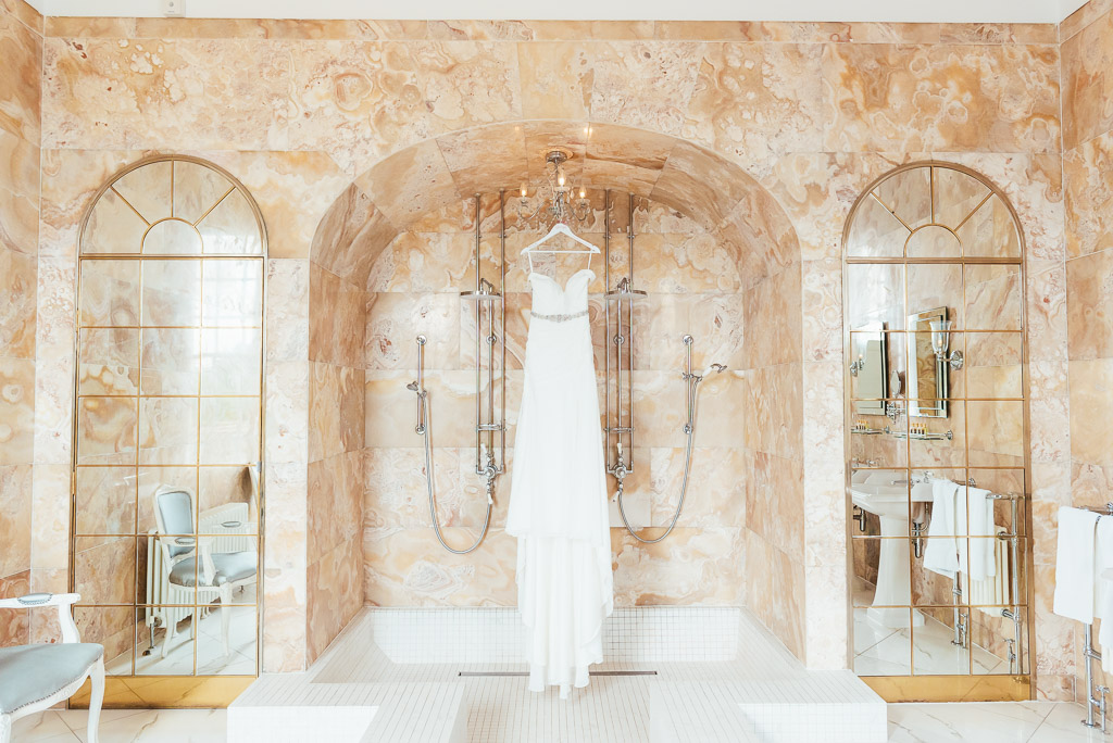 Beautiful wedding dress in glamorous marble bathroom