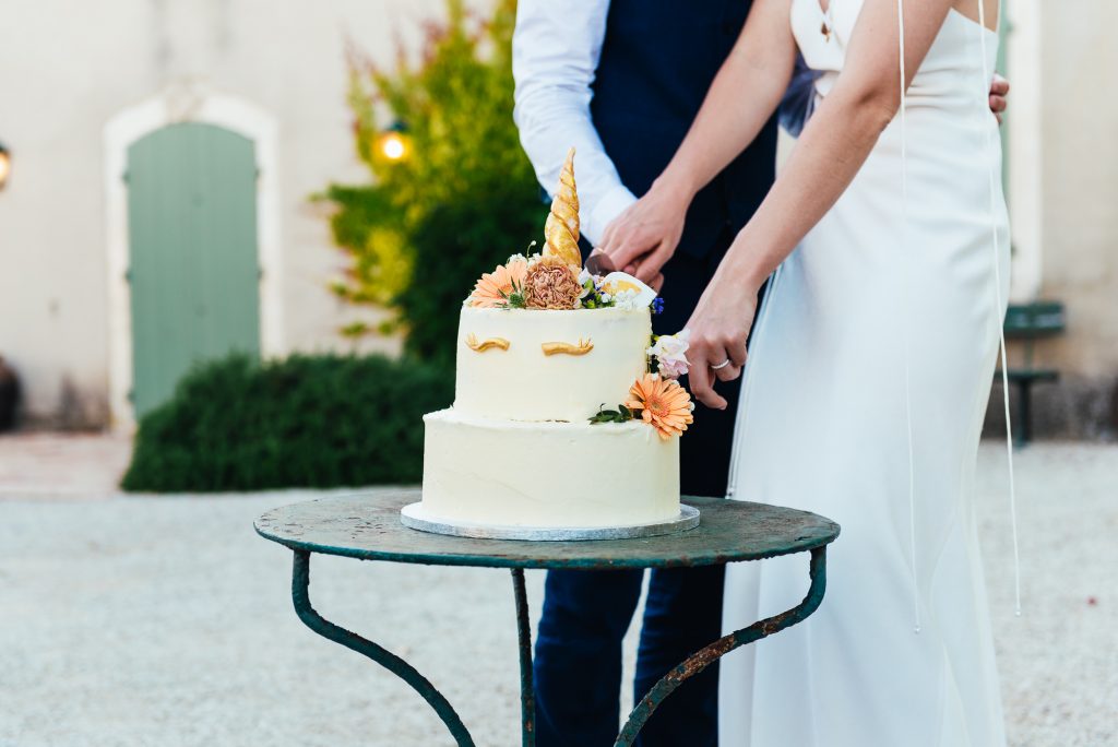 Couple cut the wedding cake in gorgeous French courtyard wedding