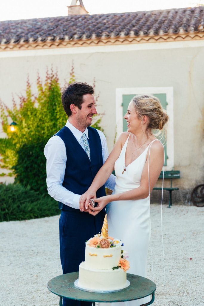 Couple cut the wedding cake in gorgeous French courtyard wedding