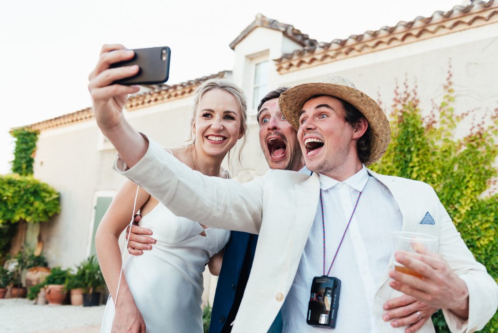 Energetic guests share a selfie with the newlyweds 