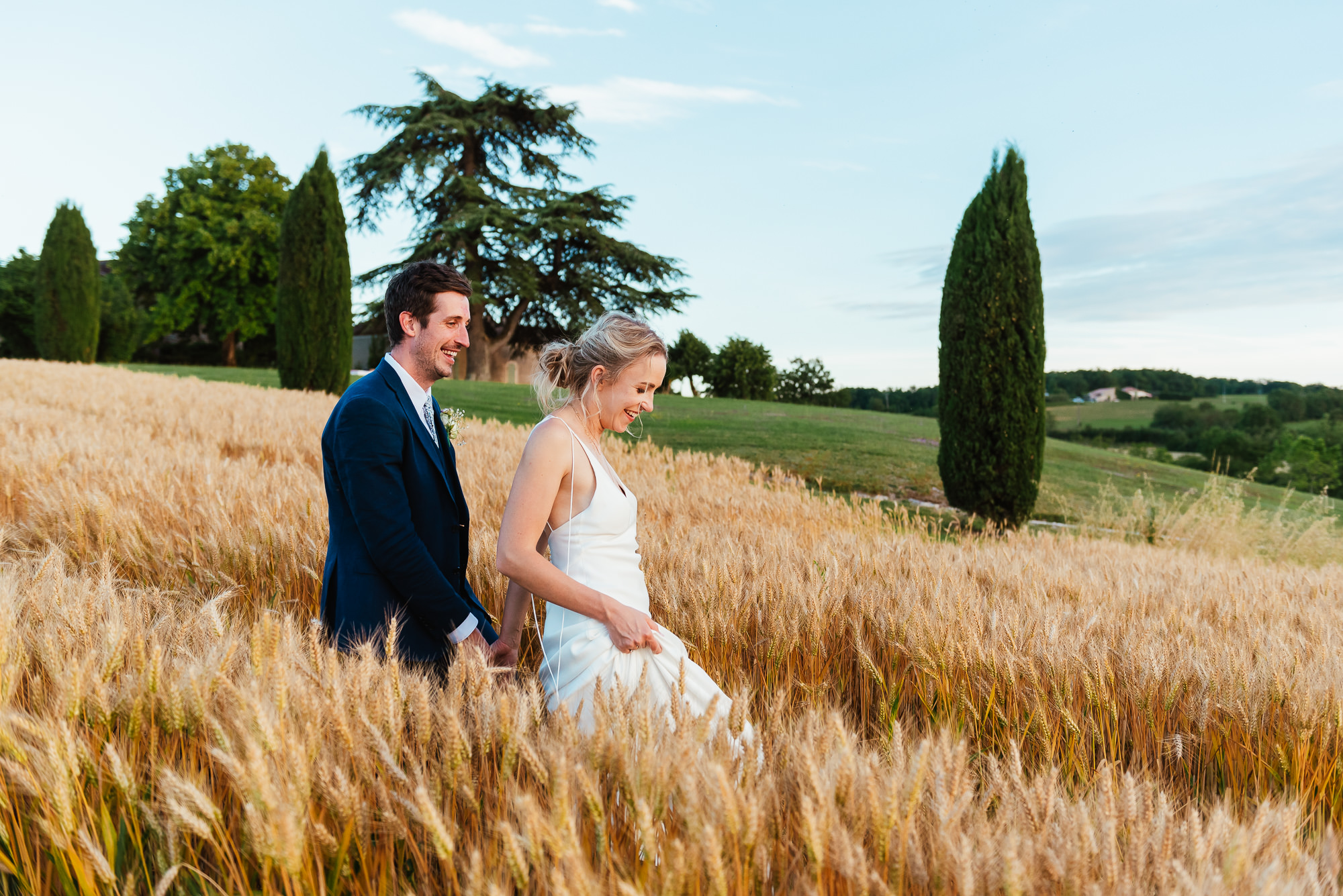 Couple walk together in the wheat fields for destination wedding photography France