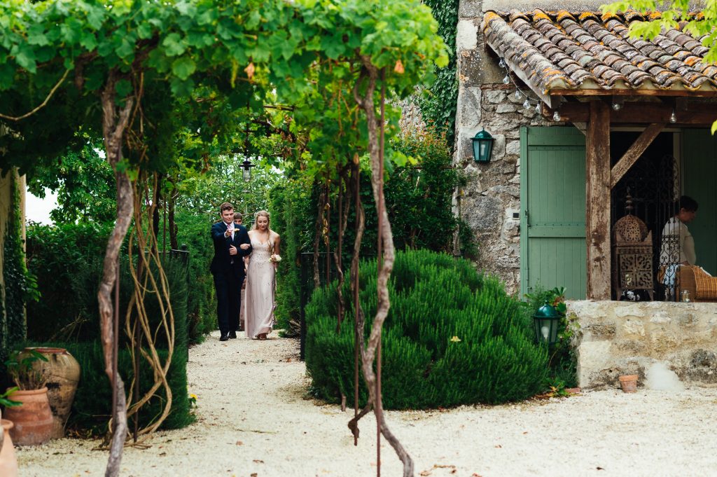 Wedding party make an entrance to vineyard courtyard wedding venue France