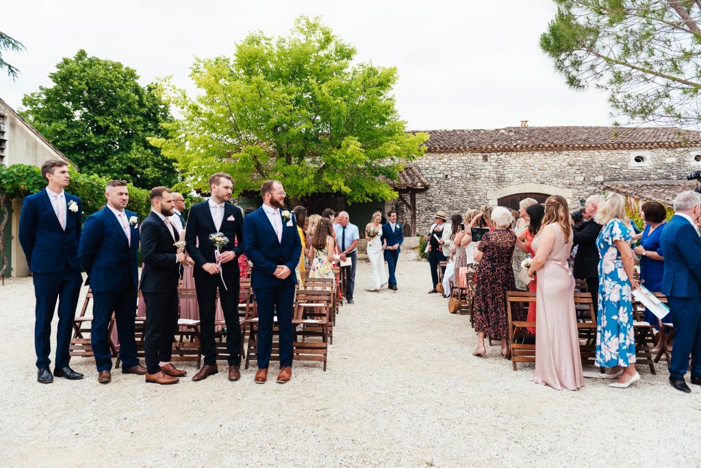 Wedding party make an entrance to vineyard courtyard wedding venue France