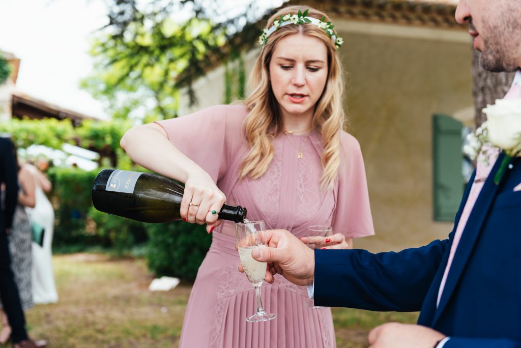 Bridesmaid pours Champagne at wedding