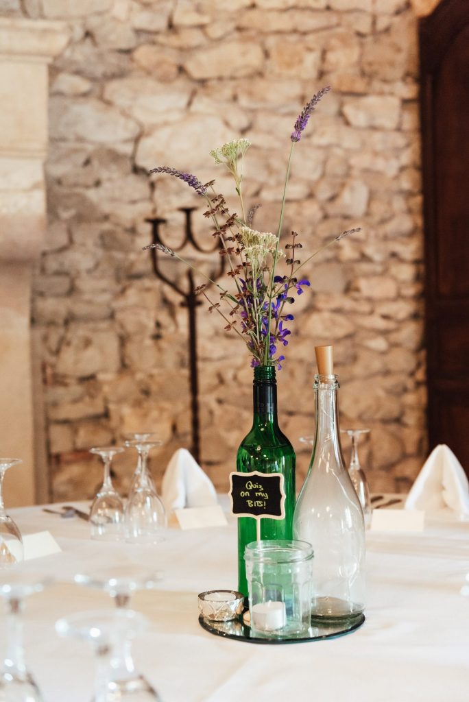 Wine bottle vases with wildflower wedding arrangements