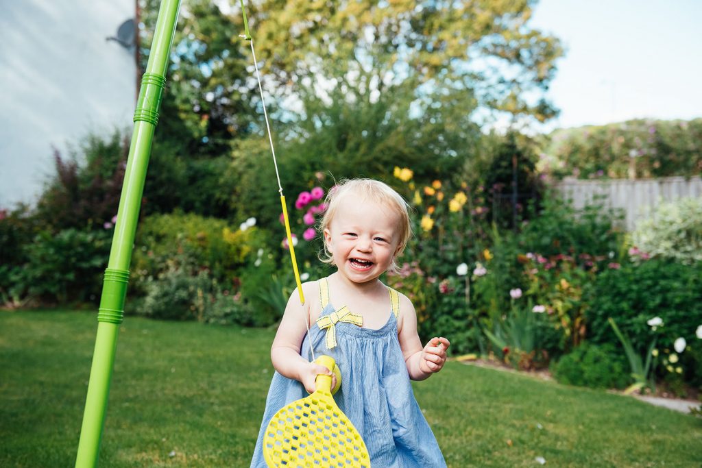 Smiley and happy little girl plays outside on Surrey family shoot