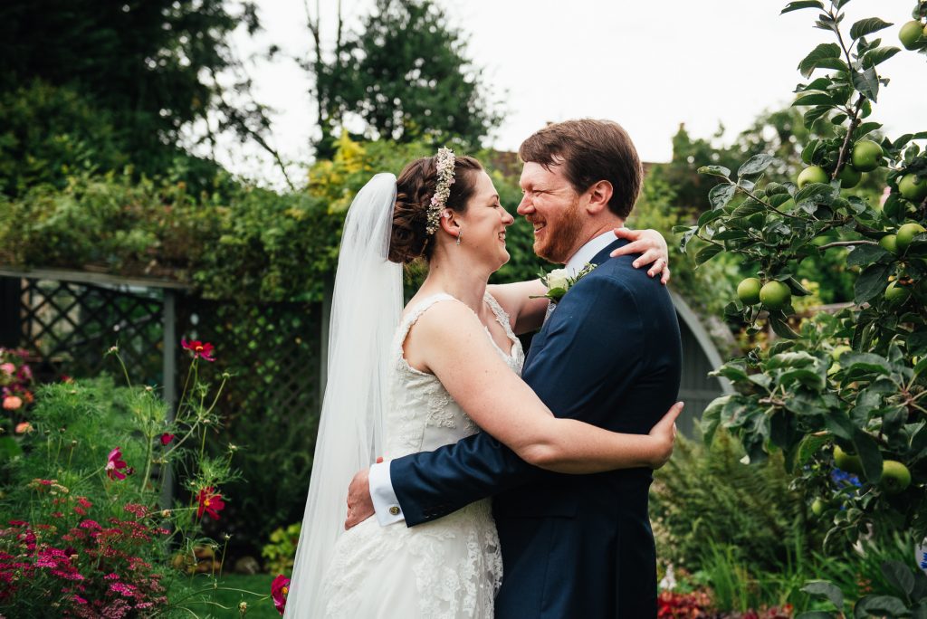 Couple embrace in a gorgeous Surrey flower garden, outdoor wedding photography