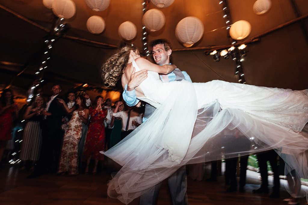 Groom scoops up his new bride for their first dance together