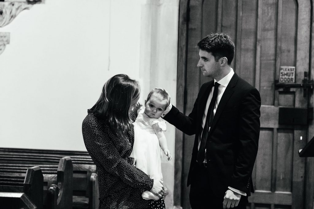 Mother, father and baby in relaxed christening photography