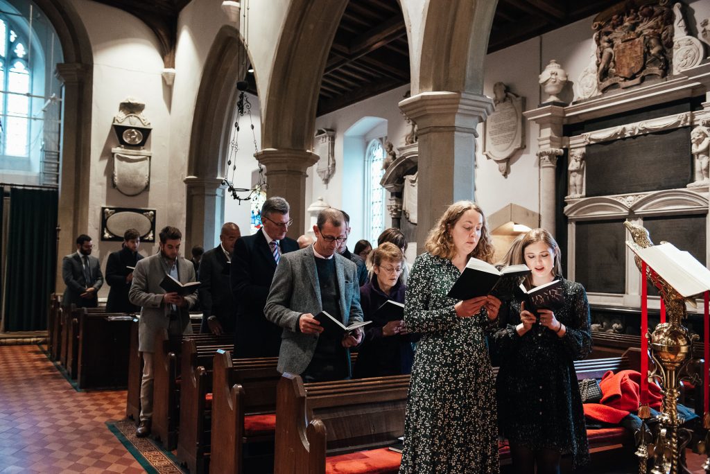 Guests sing hymns for relaxed christening photography