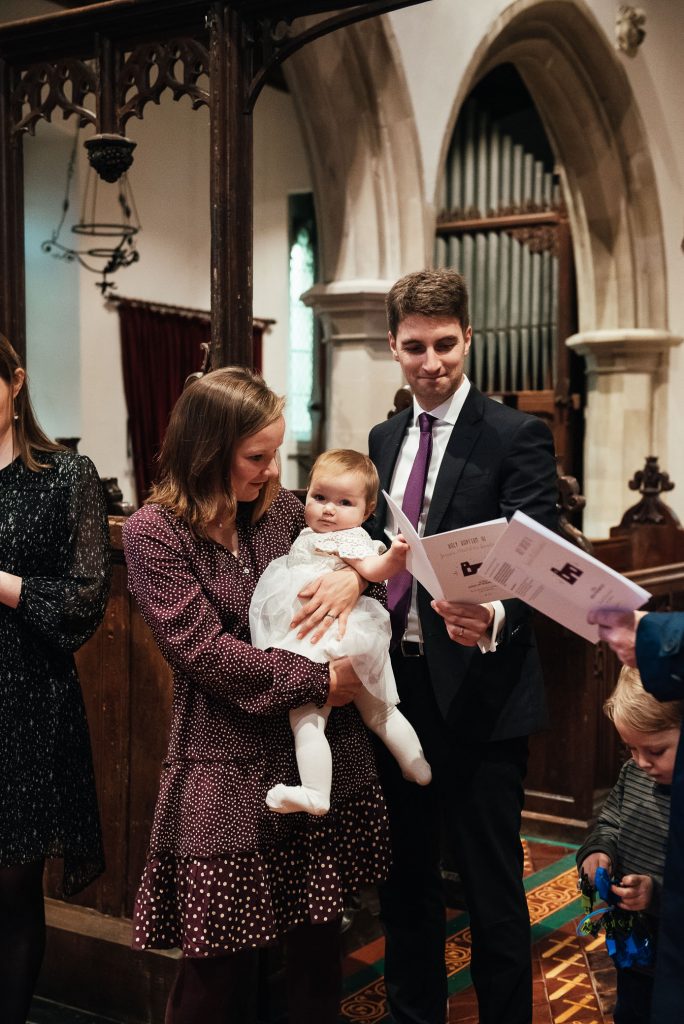 Godparents gather with parents for christening ceremony