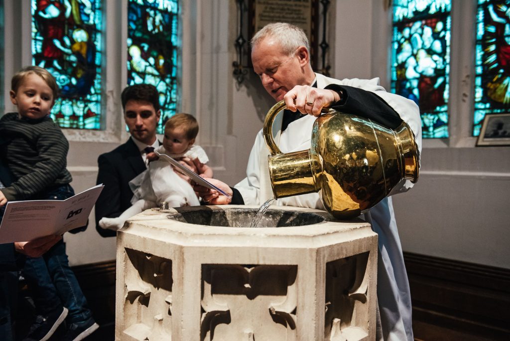 Priest fills basin with holy water