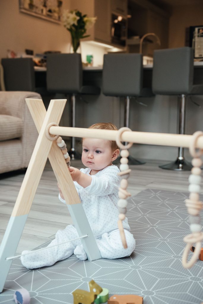 Gorgeous baby playing with wooden toys in Surrey family photo shoot