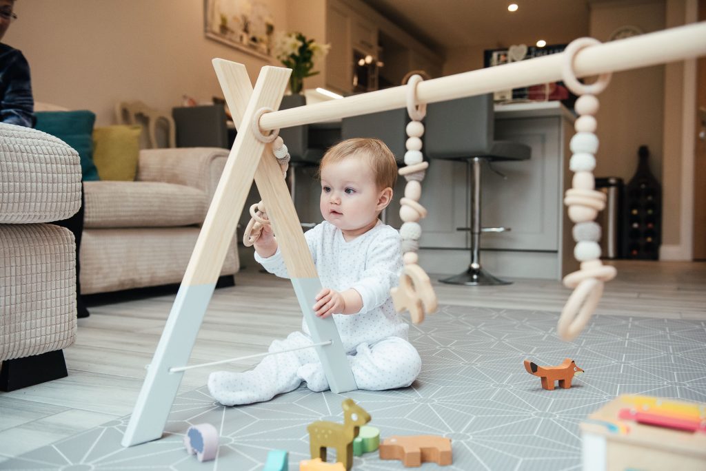 Gorgeous baby playing with wooden toys in Surrey family photo shoot