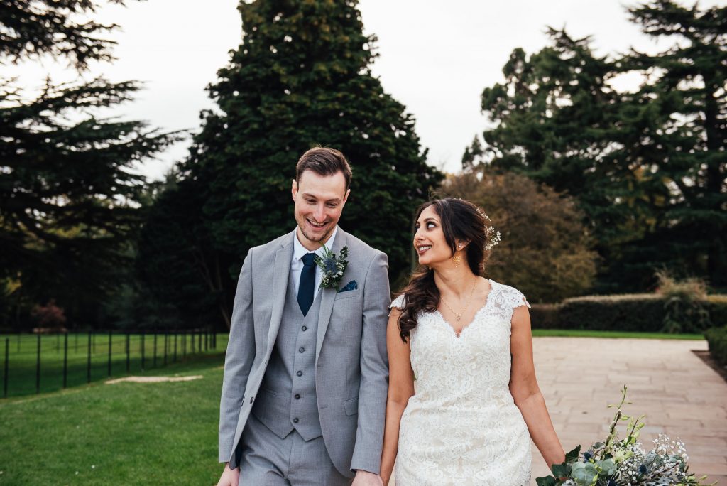 Couple smile together candidly in the grounds of Forty Hall