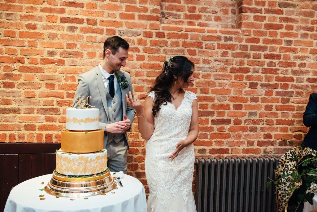 Couple cut the wedding cake at Forty Hall