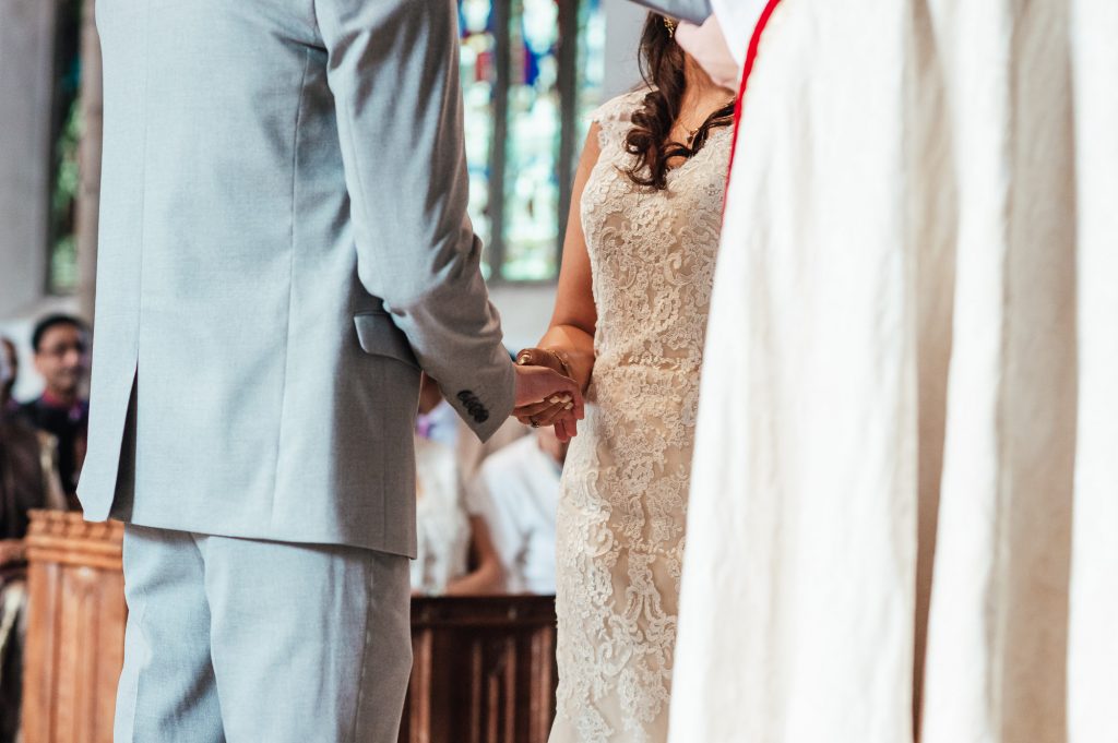 Bride and groom hold hands during ceremony
